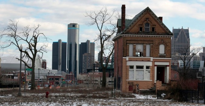 A vacant, boarded up house is seen in the once thriving Brush Park neighborhood with the downtown Detroit skyline behind it in Detroit,